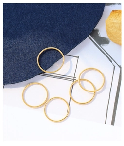 Dettaglio di cinque anelli minimalisti in acciaio al titanio placcato oro 18k su feltro
