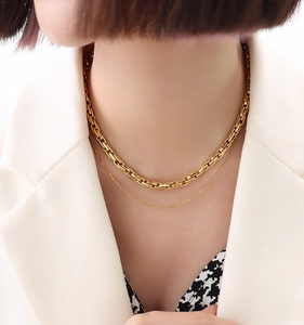 Close-up of double-layered gold titanium necklace with industrial U-shaped link design
