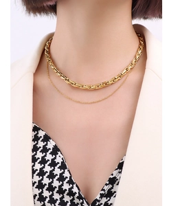 Macro view of layered 18k gold plated chunky chain necklace on a female neck
