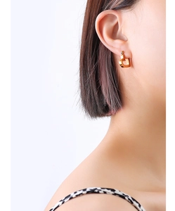 Close-up of minimalist hollow heart-shaped gold earring worn on model's ear