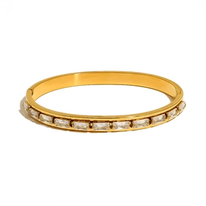 Gold plated stainless steel hinged bangle with rectangular inset crystals in minimalist style