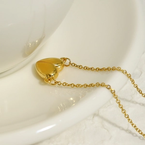 Elegant 18K gold plated stainless steel heart necklace on white ceramic holder
