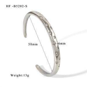 Dettaglio del bracciale a fascia argento da 58 mm con incisioni a stella e zirconi