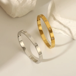 Close-up of gold and silver four-leaf clover bangles with CNC diamond setting on stone