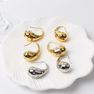 Close-up of teardrop drop earrings with sparkling cubic zirconia in gold and silver finish