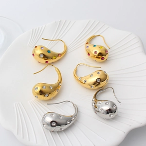 Macro detail of 18K gold and silver waterdrop earrings with zircon and colorful crystals