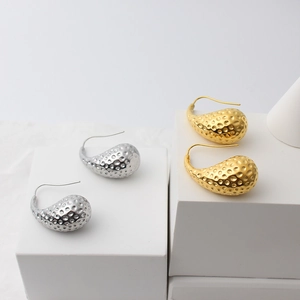 Detail view of 18K gold and silver water drop earrings with unique hammered texture finish
