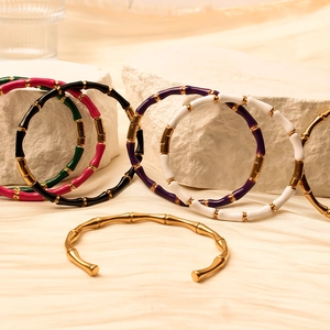 Bamboo-shaped 18K gold plated bangles with colorful enamel on white stone display