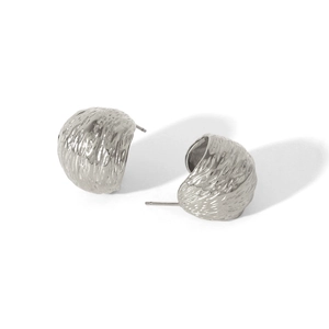 Macro view of French vintage silver-toned earrings featuring unique creased metal texture
