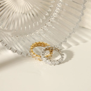 Macro detail of 18K gold and silver rings with triangular zircon channel setting