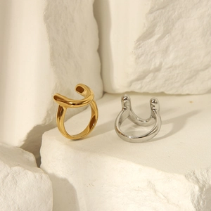 Polished 18k gold and silver U-shaped open rings displayed on a white textured stone
