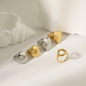 Detailed view of polished chunky gold and silver rings with heart and geometric shapes