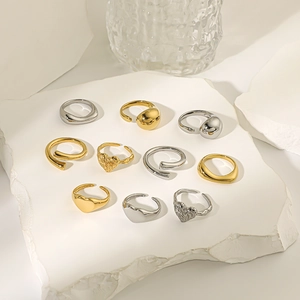 Macro display of assorted gold and silver heart-shaped open rings on textured props