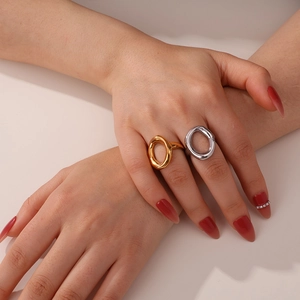 Close-up of minimalist oversized hollow oval rings in polished gold and silver finishes