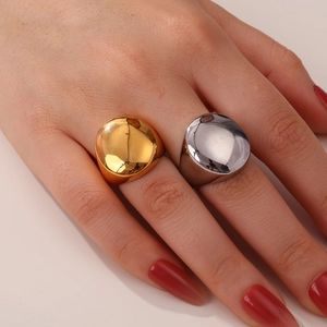 Close-up of chunky polished gold and silver dome rings worn on fingers for a sleek look