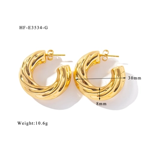 Gros plan de boucles d'oreilles croissants dorés avec texture spirale et dimensions