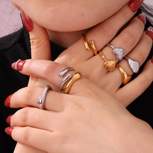 Detail of stacked gold and silver heart-shaped rings with fluid geometric designs
