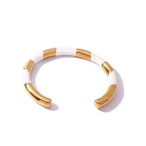 Dettaglio del bracciale aperto in titanio con smalto bianco e finitura placcata oro