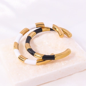 Bracciale aperto in acciaio al titanio con strisce di smalto bianco e nero dorato
