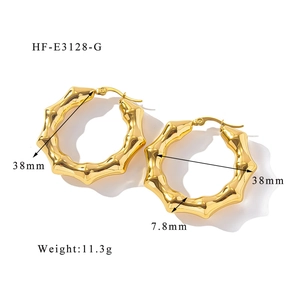 Dettaglio di orecchini a U placcati oro 18K con trama a bambù e finitura lucida a specchio