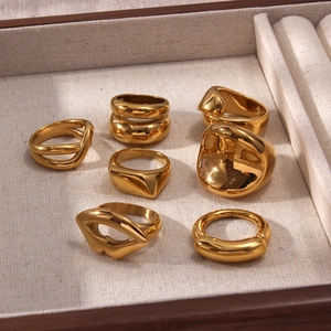 Collezione di anelli placcati oro 18K con forme organiche e geometriche in un portagioie