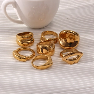 Piatto di anelli geometrici minimalisti placcati in oro 18K su tessuto bianco