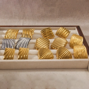 Vierkante geometrische oorknopjes met geplooide goud en zilver textuur in een tray