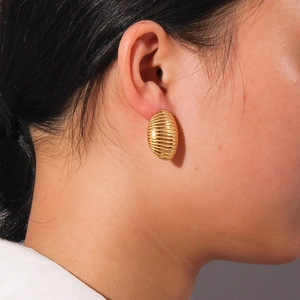 Boucles d'oreilles ovales minimalistes plaquées or 18 carats avec texture striée sur modèle
