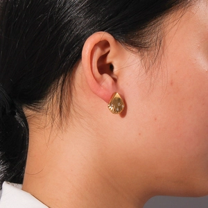 Boucles d'oreilles coquillage dorées vintage avec diamants portées sur l'oreille