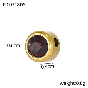 Detailed view of 6mm round gold-plated stainless steel charm with a ruby red rhinestone