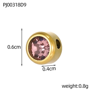 Macro detail of a 0.6cm gold-plated stainless steel charm with a faceted pink gemstone inlay