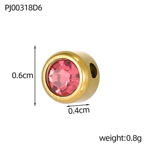 Macro detail of a 0.6x0.4cm gold-plated steel bead with pink rhinestone for DIY jewelry