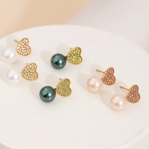 Vue détaillée de boucles d'oreilles en cœur avec strass sertis et perles élégantes