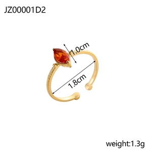 Detail view of gold-plated ring showing marquise-cut orange zircon and textured band