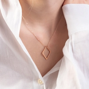 Nahaufnahme der geometrischen Rhombus-Ringhalter-Halskette in Roségold am Modell