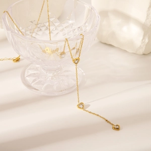 Detail of 18K gold-plated Y-shaped heart tassel necklace with sparkling zircon stones