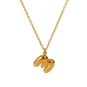 Detailed close-up of a 18K gold-plated bubble letter M pendant on a fine cross chain