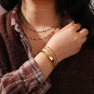 Gros plan d'un ensemble de bijoux plaqués or 18 carats et argent sur chemise