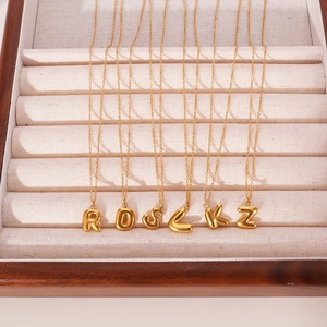 18K gold plated bubble initial letter pendant necklaces displayed in a luxury jewelry box