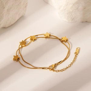 Detail of gold double-layer snake chain bracelet with stars and S.STEEL engraved tag