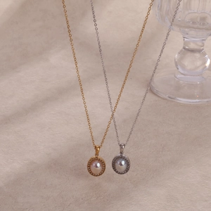 Detailed macro of gold and silver vintage oval pearl pendants with pavé zircon accents