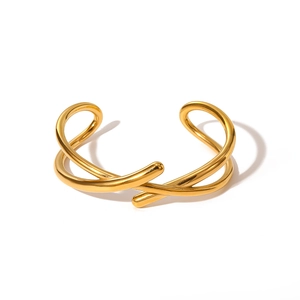 Détail du bracelet en acier titane plaqué or 18K avec un design minimal à double fil croisé