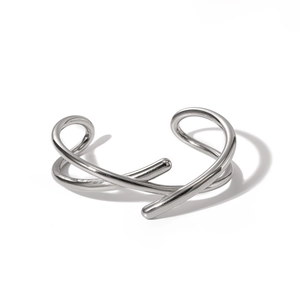 Détail du design entrelacé géométrique du bracelet jonc croisé en argent poli