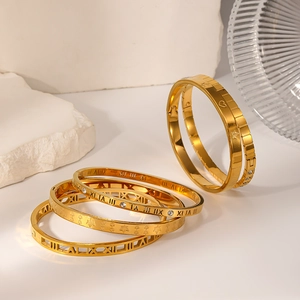 Set of six gold plated stainless steel bangles with Roman numerals and leaf motifs