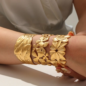 Three 18K gold plated titanium steel wide bangles with floral and leaf patterns
