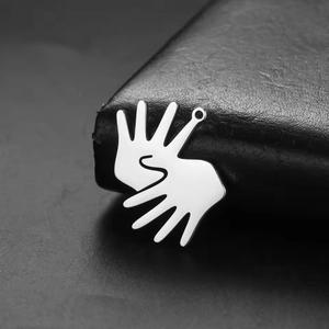 Pendentif mains entrelacées en acier inoxydable poli sur fond de texture noire