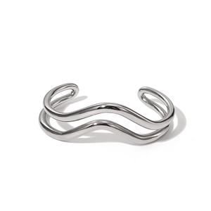 Gros plan sur un bracelet manchette argenté double vague avec finition métallique polie
