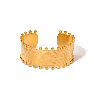 Detail eines goldenen Armreifs mit horizontaler Bürstung und verzierten Perlenkanten