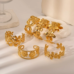 Macro detail of 18K gold plated stainless steel floral bangles on white stone