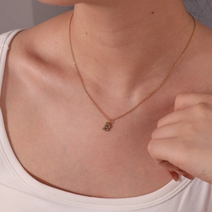 Collana in acciaio al titanio placcata oro 18K con ciondolo lettera B e cristalli su modella